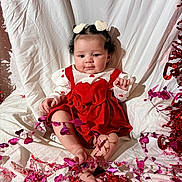 Avaya joined the competition — help win amazing prizes! baby, child, infant, red_dress, heart_clips, curly_hair, pink_decorations, red_decorations, white_backdrop, sitting, barefoot, cute, festive, celebration, portrait, adorable, indoors, holiday_theme, smiling, young