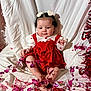 baby, child, infant, red_dress, heart_clips, curly_hair, pink_decorations, red_decorations, white_backdrop, sitting, barefoot, cute, festive, celebration, portrait, adorable, indoors, holiday_theme, smiling, young