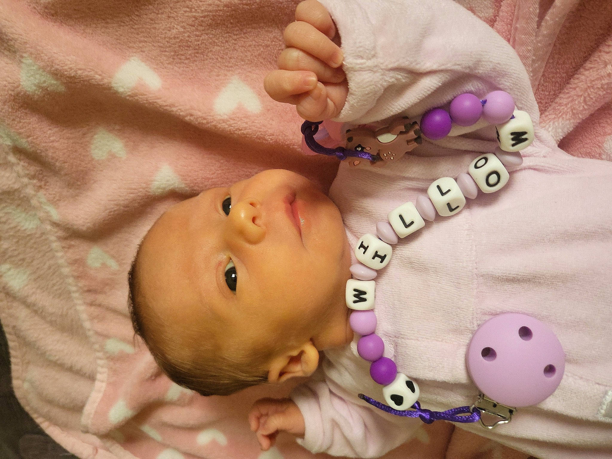 Willow participe au concours pour gagner de l'argent avec cette photo : baby, baby_products, baby_toddler_clothing, cheek, child, comfort, eyebrow, eyelash, finger, gesture, jewellery, mouth, neck, nose, pattern, person, pink, product, skin, toddler