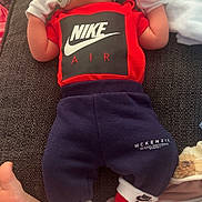 Scott joined the competition — help win amazing prizes! baby, infant, pacifier, red_hat, mittens, nike_air, sportswear, couch, blanket, foot, clothing, red_shirt, blue_pants, red_socks, indoor, resting, child, cute, relaxing, portrait