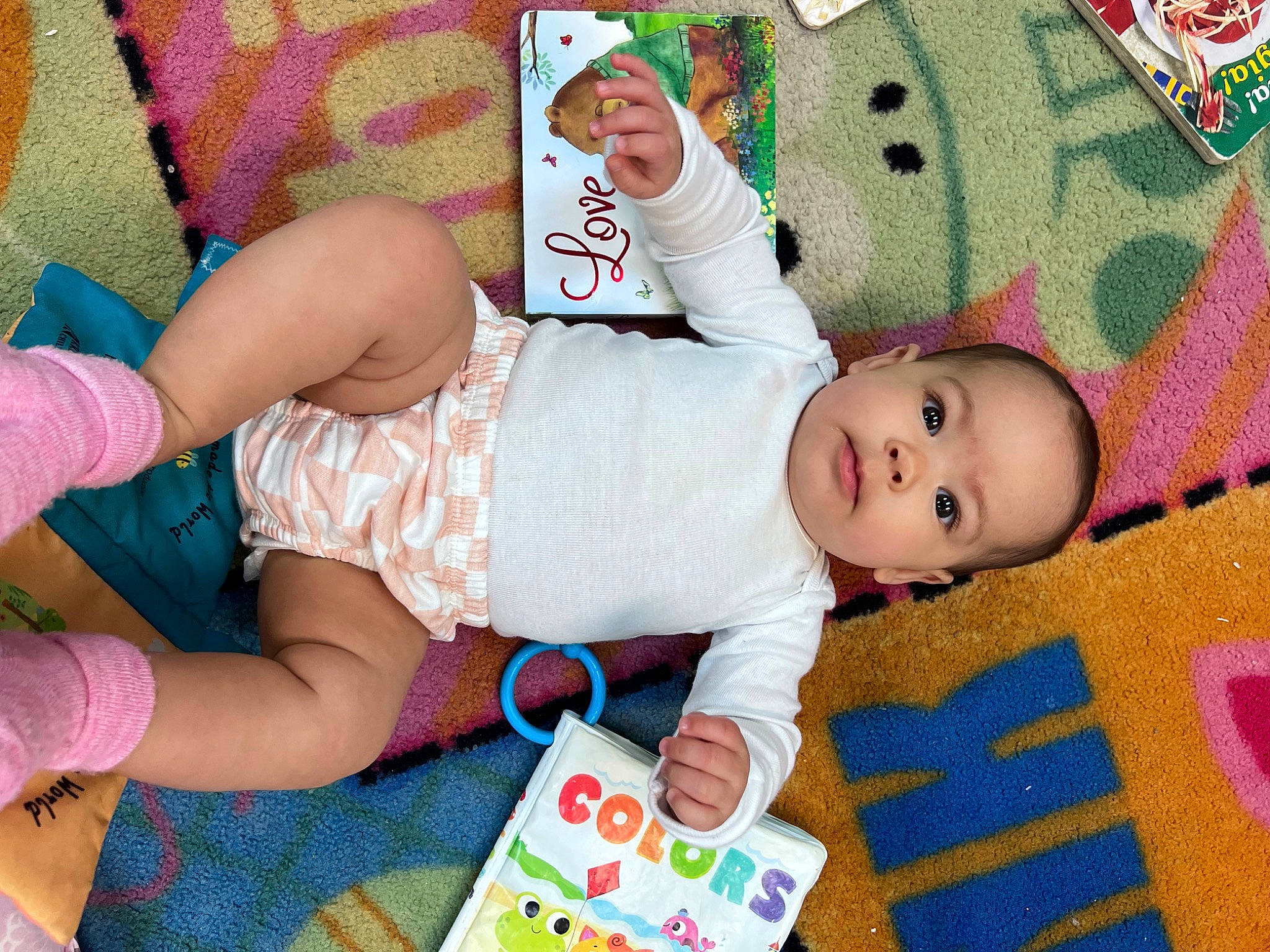 Violet is registered to the contest to win money with this photo: baby, baby_products, baby_toddler_clothing, cheek, child, comfort, foot, fun, happy, human_leg, pattern, person, pink, product, room, skin, smile, sock, textile, thigh