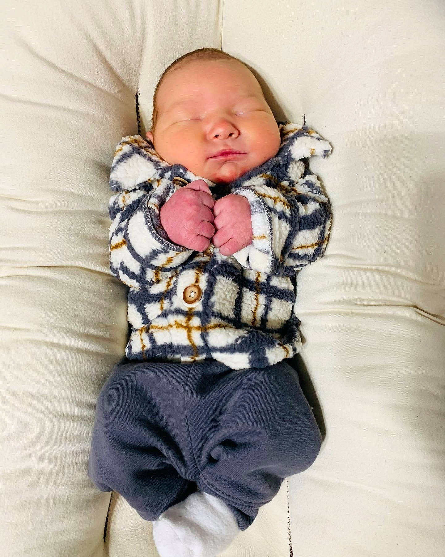 Kaysen is registered to the contest to win money with this photo: arm, baby, baby_products, baby_sleeping, baby_toddler_clothing, child, collar, comfort, happy, knee, linens, neck, pattern, person, plaid, purple, sitting, sleeve, t_shirt, thigh