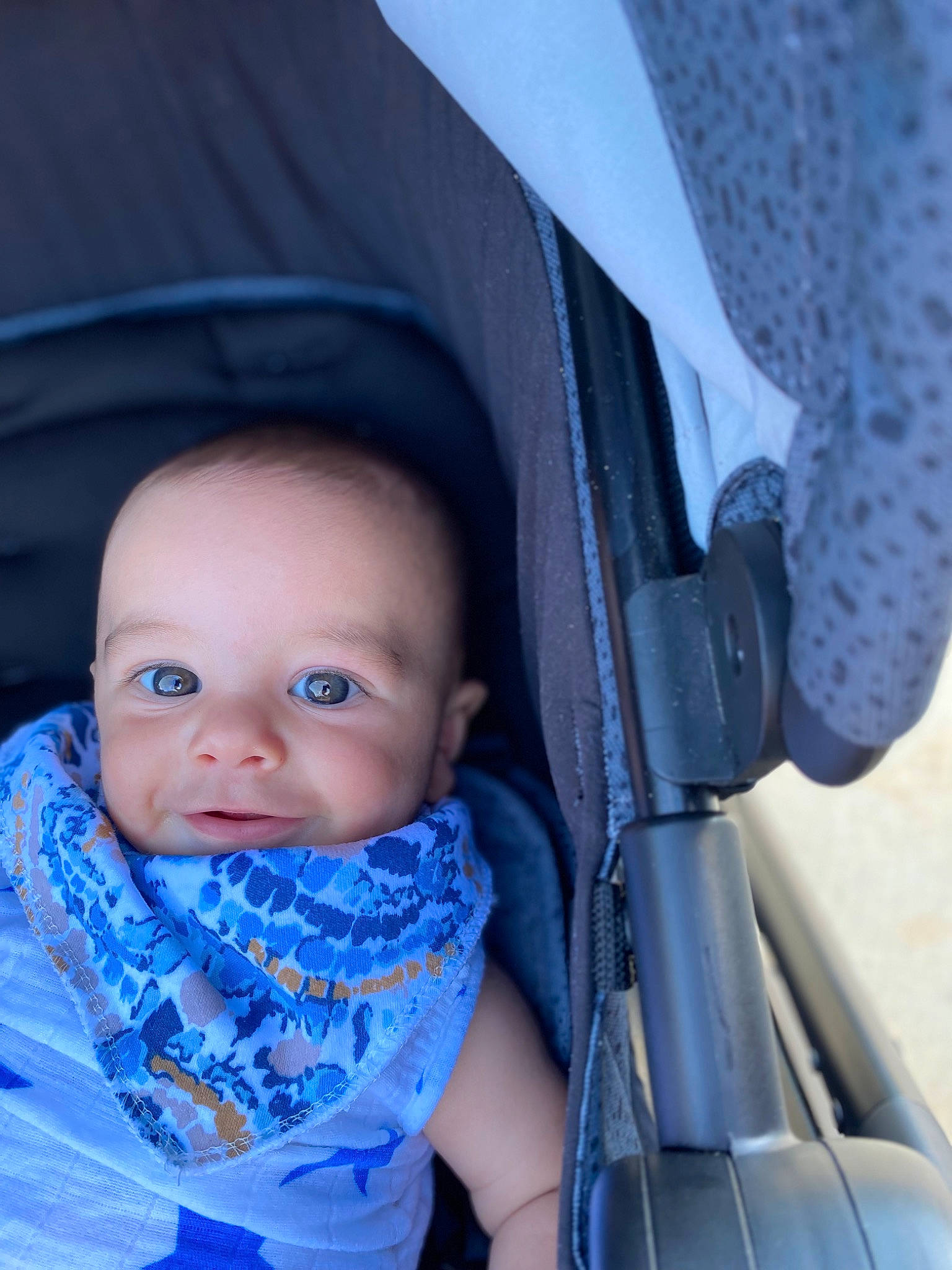 Kodi is registered to the contest to win money with this photo: auto_part, azure, baby, baby_carriage, baby_products, baby_toddler_clothing, blue, cheek, child, comfort, electric_blue, eye, fashion_accessory, happy, iris, pattern, person, sitting, skin, textile