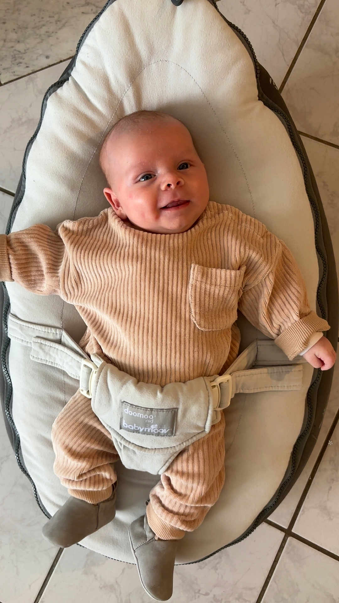 Hugo participe au concours pour gagner de l'argent avec cette photo : baby, infant, smile, clothing, ribbed_fabric, baby_seat, cushion, footwear, boots, floor_tiles, indoor, child, person, cute, comfort, relaxed, happy, home, small, young