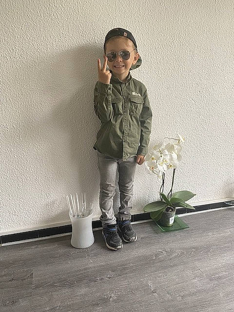 Adam participe au concours pour gagner de l'argent avec cette photo : art, face, floor, flooring, flower, grass, human_leg, joy, knee, leg, monochrome_photography, person, plant, road_surface, shoe, sitting, sleeve, smile, standing, toddler