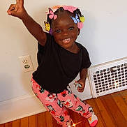 Ava joined the competition — help win amazing prizes! child, smiling, peace_sign, indoor, colorful, butterflies, hair_accessories, black_tshirt, pink_pants, patterned_clothing, wooden_floor, white_wall, vent, socks, happy, standing, playful, toy, footwear, young_kid