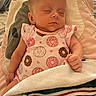 Allie is registered to the contest to win money with this photo: baby, sleeping, infant, blanket, onesie, donut_pattern, cute, peaceful, cozy, indoor, child, portrait, soft_lighting, hand, head, face, clothing, rest, comfort, nap