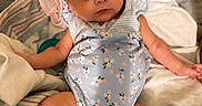 Allie is registered to the contest to win money with this photo: baby, infant, child, bow, headband, onesie, floral_pattern, blanket, fabric, cute, portrait, indoors, skin, face, eyes, small_hands, comfortable, laying_down, cozy, expression