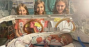 Allie is registered to the contest to win money with this photo: hospital, incubator, newborn, baby, child, children, medical_equipment, healthcare, smiling, curious, neonatal_unit, infant, tubes, monitoring, patient, person, bed, caregiver, nursery, hospital_room