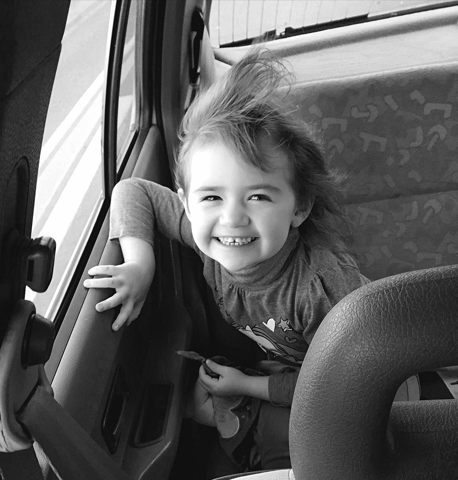Kéllianna participe au concours pour gagner de l'argent avec cette photo : auto_part, black, black_and_white, car, car_seat, child, family_car, joy, monochrome, person, photography, sitting, smile, style, toddler, vehicle