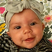Makayla joined the competition — help win amazing prizes! baby, cheeks, child, closeup, clothing, cute, eyes, face, floral, happy, headband, headwear, indoors, infant, patterned_blanket, person, portrait, skin, smiling, young