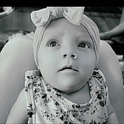 Oaklee joined the competition — help win amazing prizes! baby, child, headband, bow, floral_clothing, portrait, indoor, person, infant, looking_up, close_up, black_and_white, cute, young_child, face, expression, sitting, soft_light, legs, adult