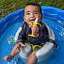 baby, child, pool, water, toy, teether, banana_toy, seat, swimming_pool, outdoor, grass, summer, playful, cute, infant, sitting, smiling, happy, clothing, foot