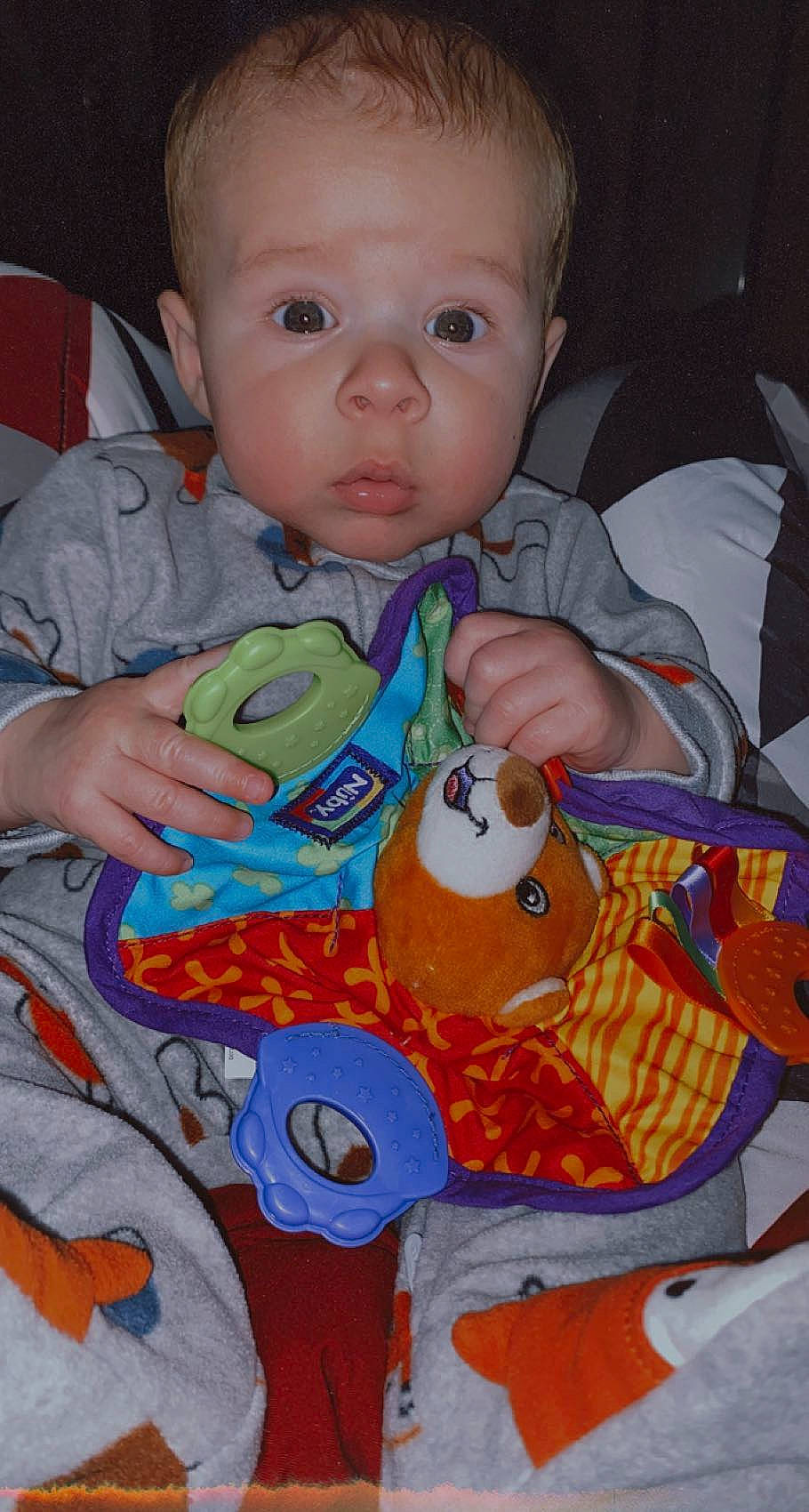 Maxton is registered to the contest to win money with this photo: baby, baby_products, baby_toddler_clothing, cheek, child, eye, hand, iris, linens, mouth, nose, orange, organ, person, product, sitting, skin, spider_man, textile, toddler