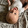 baby, infant, smiling, lying_down, blue_eyes, white_onesie, blanket, leaf_pattern, cute, happy, skin, head, face, child, young, indoors, soft_light, closeup, portrait, toddler
