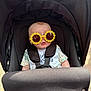 baby, stroller, sunglasses, yellow, flower, baby_bib, infant, child, seatbelt, outdoor, sunshade, clothing, cute, portrait, head, face, fashion, accessory, seat, babywear