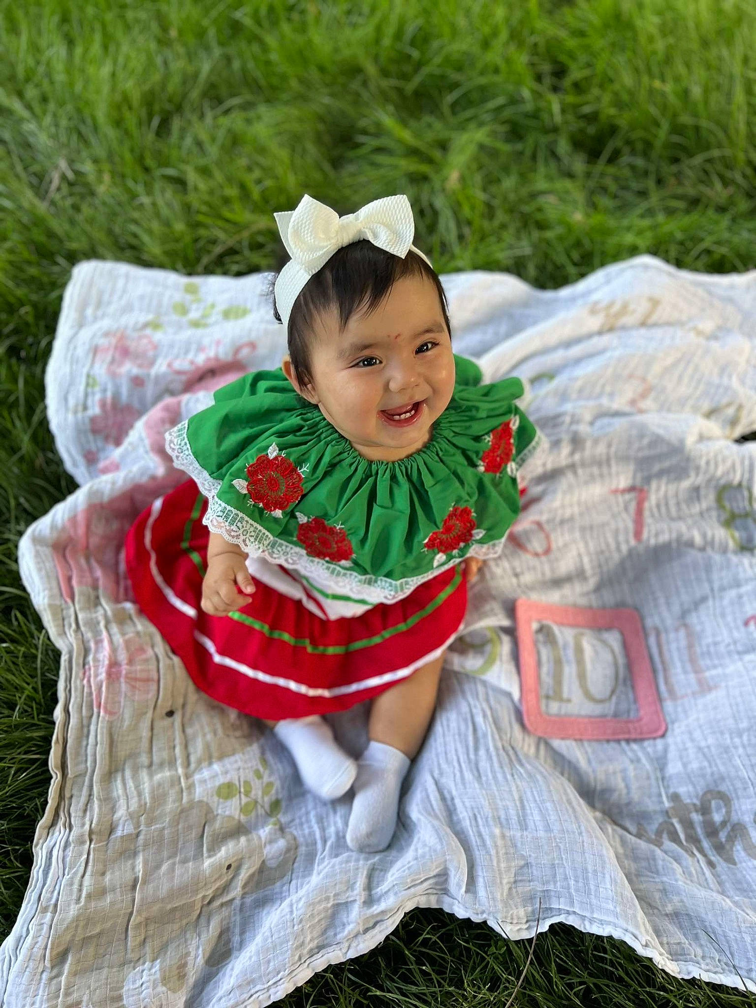 Analina joined the competition — help win amazing prizes! baby, baby_toddler_clothing, child, costume, costume_hat, dress, event, eye, grass, happy, headgear, human_body, joy, linens, people_in_nature, person, plant, sitting, smile, toddler