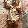 baby, infant, smiling, lying_down, blanket, hearts_pattern, dress, usa_flag, pacifier, happy, cute, child, skin, hand, foot, indoors, fabric, soft, portrait, person