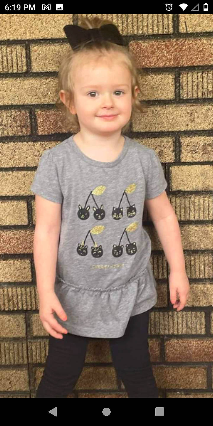 Riley joined the competition — help win amazing prizes! baby_toddler_clothing, brick, brickwork, child, cool, face, facial_expression, gesture, grey, hair, happy, human, joy, pattern, person, sleeve, smile, standing, t_shirt, textile