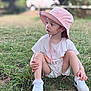 Victoire participe au concours pour gagner de l'argent avec cette photo : child, toddler, grass, outdoor, hat, bucket_hat, white_sneakers, sitting, curious, casual_clothing, nature, daylight, young_child, cute, portrait, person, summer, shoes, greenery, playful