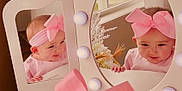 Lunden is registered to the contest to win money with this photo: baby, pink_bow, headband, mirror, reflection, vanity, lights, cute, smile, infant, child, indoor, furniture, decor, window, curiosity, portrait, adorable, pink_clothing, hands