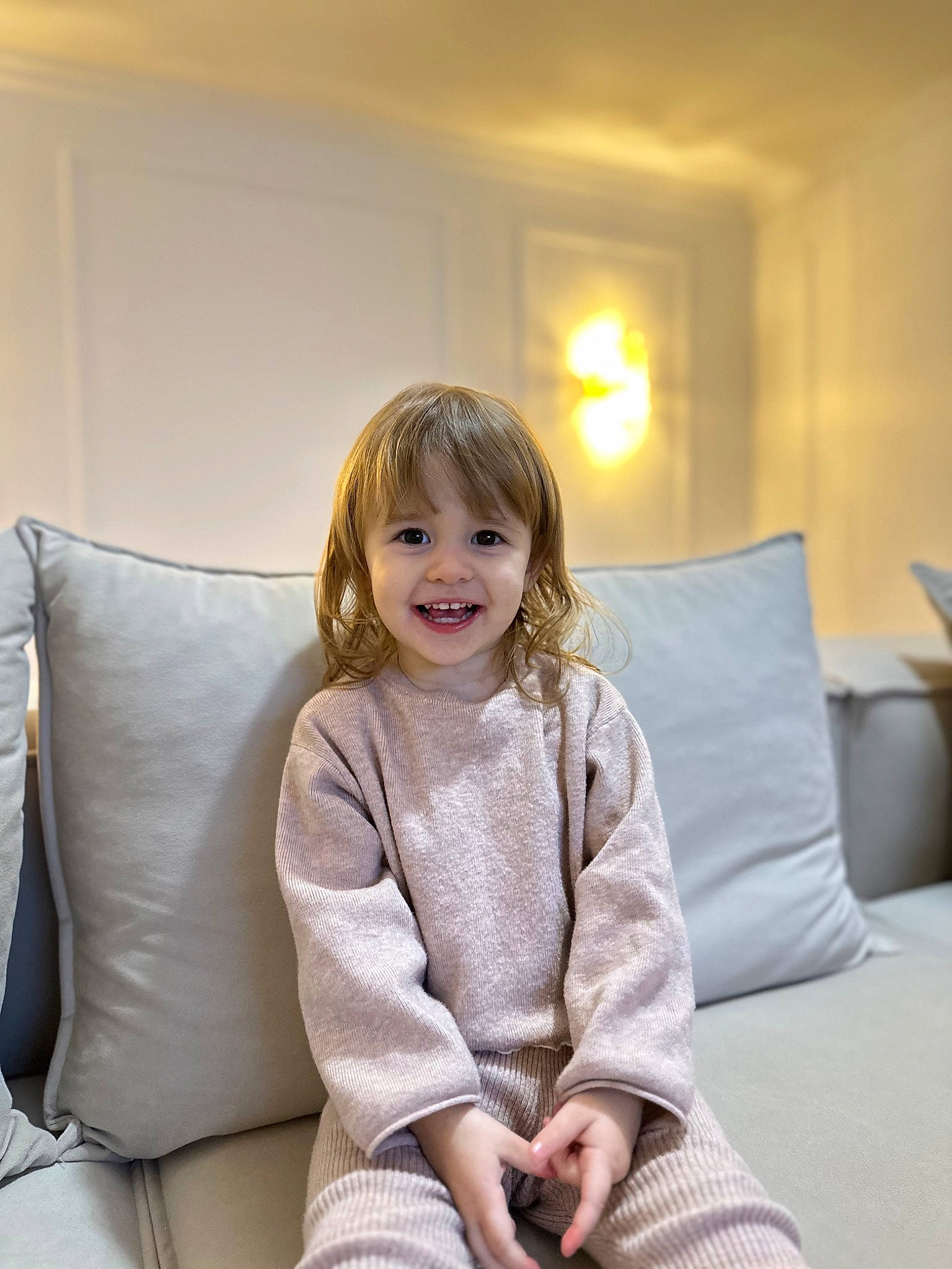 Milana a rejoint le concours — aidez-le/la à gagner de superbes lots ! blond, child, comfort, couch, flash_photography, flooring, fun, hair, happy, head, human_leg, joy, knee, living_room, person, pillow, room, sitting, smile, throw_pillow