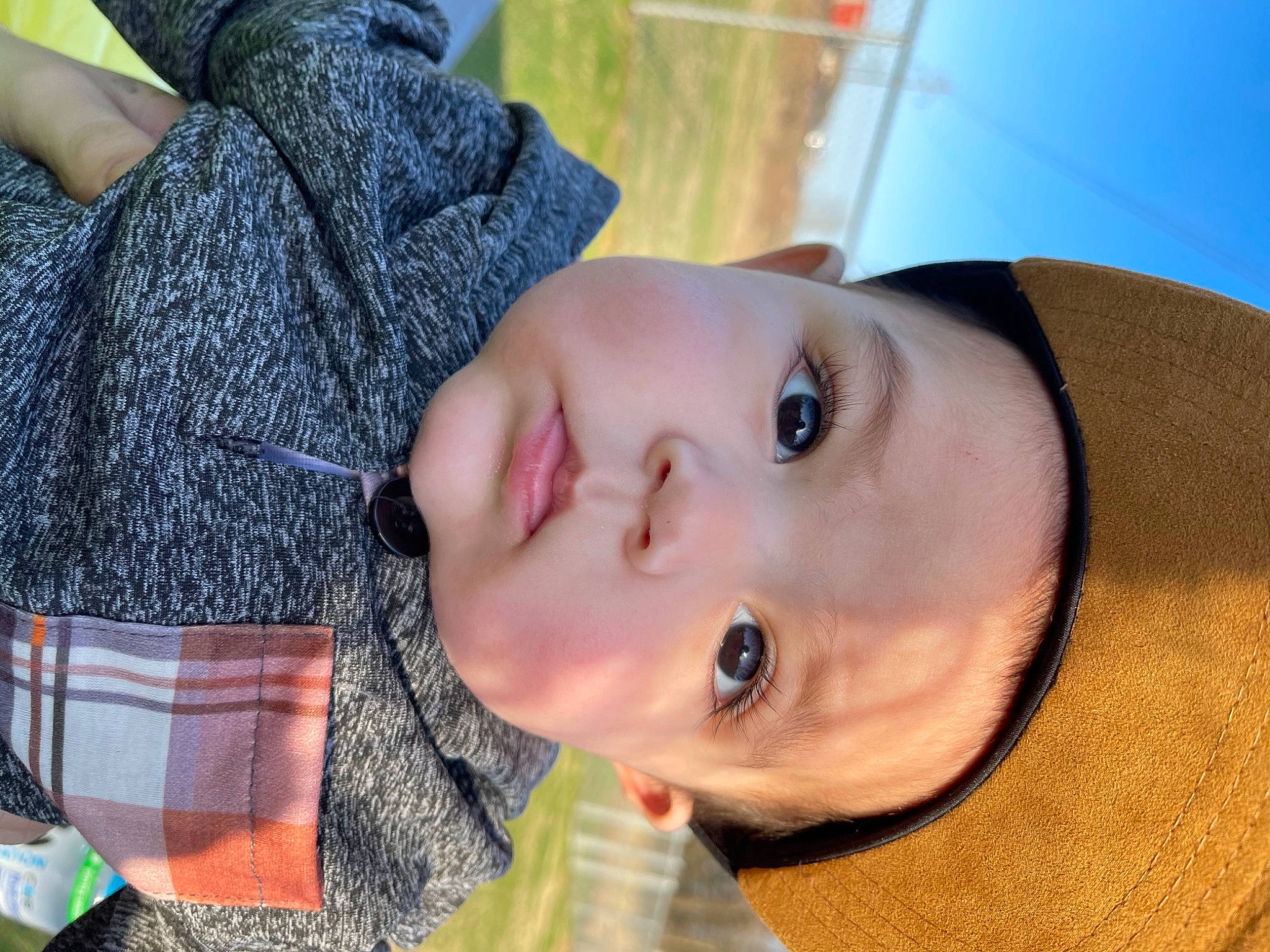 Jase is registered to the contest to win money with this photo: child, eye, eyelash, grass, happy, head, iris, jaw, lip, mouth, neck, nose, organ, person, plant, skin, smile, tartan, toddler, tree