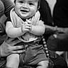 baby, infant, smile, clapping, bib, sneakers, person, adult, black_and_white, portrait, happy, indoor, people, seated, jeans, hand, face, cute, child, holding