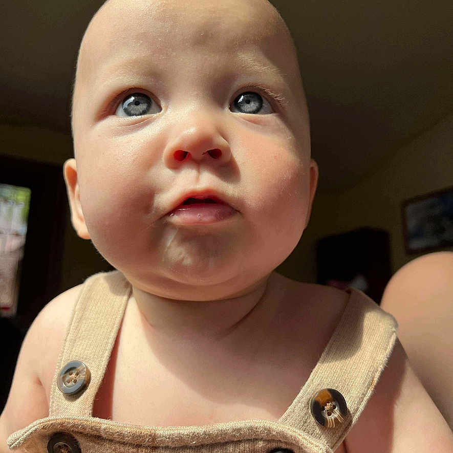 River joined the competition — help win amazing prizes! baby, beige_clothing, blue_eyes, buttons, child, chubby_cheeks, close_up, curious_expression, cute, face, head, human, indoor, infant, natural_light, person, portrait, skin, soft_light, young_child