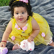 Michelle joined the competition — help win amazing prizes! baby, bright_colors, child, curly_hair, cute, grass, gray_blanket, happy, headband, innocence, outdoor, person, pink_flowers, playful, plush_toy, portrait, sitting, smiling, toddler, yellow_dress