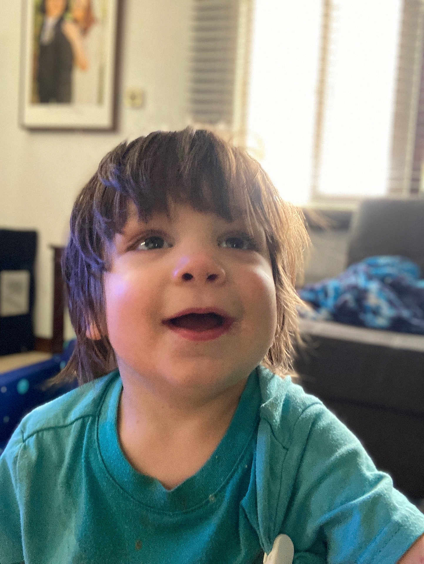 Deca joined the competition — help win amazing prizes! toddler, child, smiling, indoor, portrait, happy, person, casual_clothing, living_room, blurred_background, short_hair, blue_shirt, furniture, couch, photograph, window, daylight, expression, face, cute
