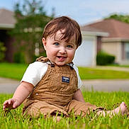 Jaxson joined the competition — help win amazing prizes! toddler, child, grass, outdoor, smiling, barefoot, overalls, short_sleeves, blue_eyes, brown_hair, house, suburban, daylight, greenery, happy, sitting, portrait, nature, casual_clothing, playful