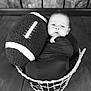 baby, infant, newborn, basket, football, prop, swaddle, portrait, black_and_white, wood_floor, wood_paneling, cute, cozy, sleeping, face, eyes, indoor, soft_texture, photography, blanket