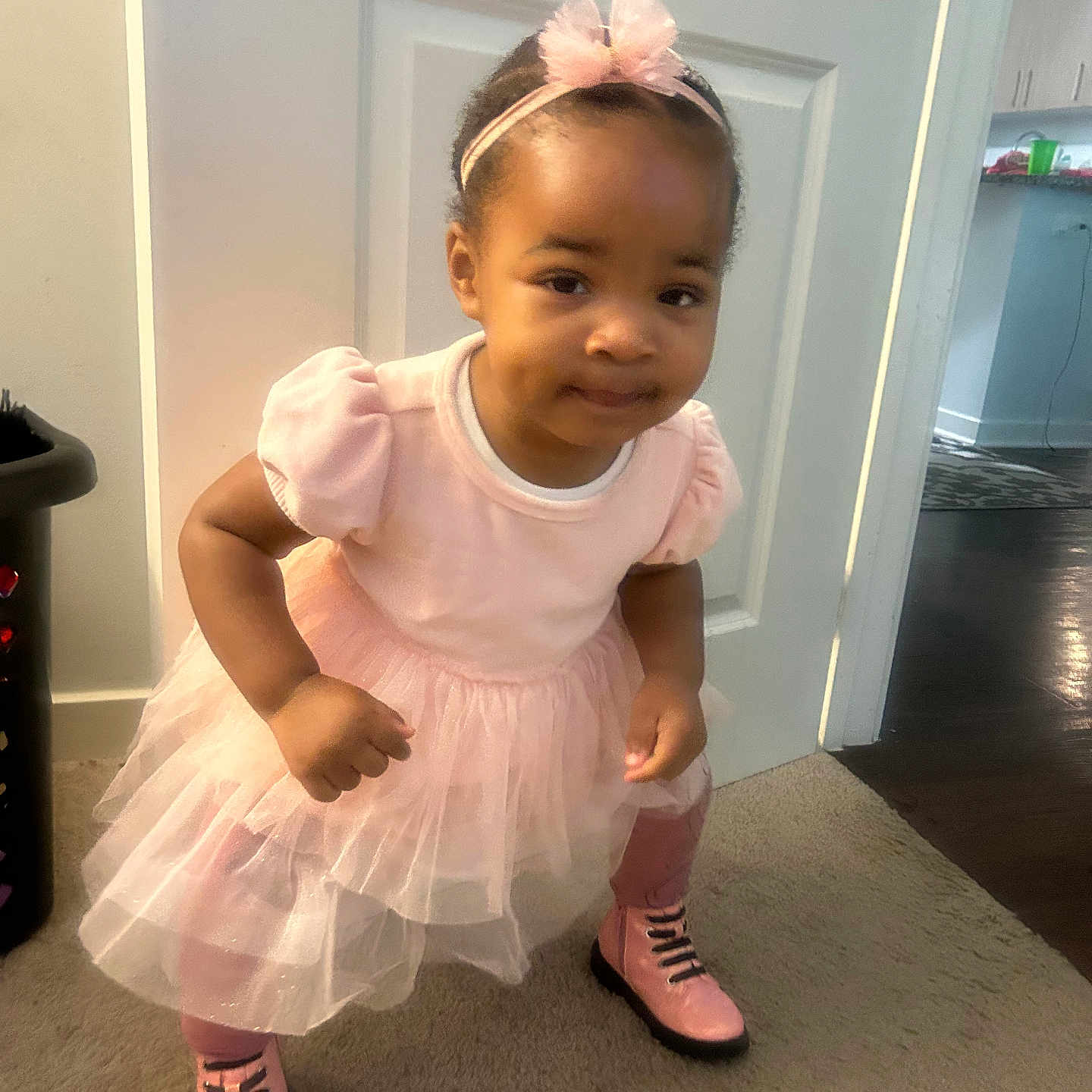 Lariah is registered to the contest to win money with this photo: child, toddler, girl, portrait, smiling, pink_dress, hair_bow, headband, boots, standing, indoor, hallway, door, carpet, home, fashion, cute, full_body, flash_photography, playful