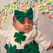 Amelia joined the competition — help win amazing prizes! baby, infant, headband, green_bow, sleeping, closed_eyes, clover, shamrock, white_outfit, lace, ruffled_sleeve, skirt, pastel_candies, star_candies, heart_candies, portrait, cute, soft_lighting, newborn, accessory