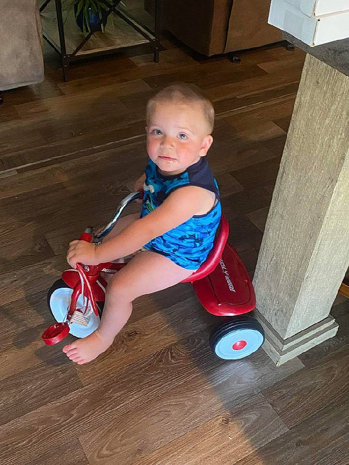 Isaac is registered to the contest to win money with this photo: baby_toddler_clothing, child, electric_blue, finger, floor, flooring, foot, hardwood, human_leg, joint, knee, leg, leisure, person, shipping_box, skin, thigh, toddler, varnish, wood