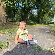 Tayron participe au concours pour gagner de l'argent avec cette photo : toddler, child, smile, outdoor, park, path, leaves, sunlight, greenery, shorts, tshirt, shoes, happy, sitting, nature, daylight, person, playful, casual, young