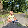 toddler, child, smile, outdoor, park, path, leaves, sunlight, greenery, shorts, tshirt, shoes, happy, sitting, nature, daylight, person, playful, casual, young