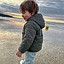 child, boy, jacket, pants, sneakers, beach, sand, sea, sunset, clouds, yellow_ball, water, shore, walking, outdoor, nature, sky, reflection, happy, play