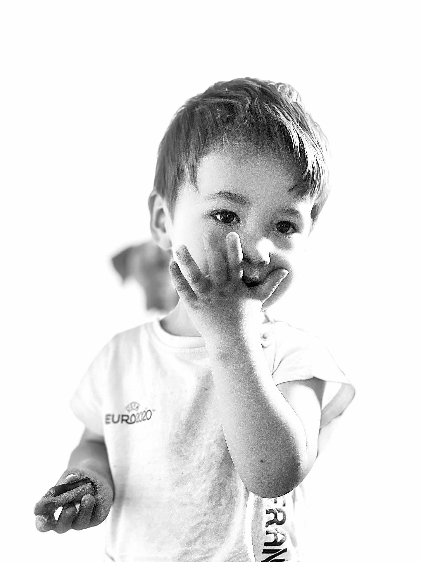 Liam participe au concours pour gagner de l'argent avec cette photo : child, boy, cookie, snack, hand, face, black_and_white, tshirt, short_sleeve, young, cute, portrait, closeup, smiling, food, euro2020, casual, indoor, expression, person