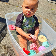 Eros joined the competition — help win amazing prizes! toddler, child, water, plastic_tub, toys, outdoor, sunlight, concrete, play, summer, swim_shirt, curious, puddle, reflection, shadow, colorful, daytime, baby, fun, sitting