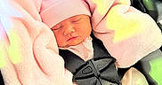 Adhara is registered to the contest to win money with this photo: baby, car_seat, child, closeup, clothing, cute, hat, indoors, infant, newborn, peaceful, person, pink_blanket, resting, safety_buckle, seat, sleeping, soft_texture, toddler, wrapped