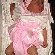 Ava is registered to the contest to win money with this photo: baby, infant, pink_bow, headband, pink_outfit, white_top, blanket, lying_down, newborn, cute, soft_texture, socks, baby_clothes, child, portrait, indoors, sleeping_area, small_person, resting, adorable