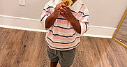 Saint is registered to the contest to win money with this photo: child, toddler, boy, standing, portrait, indoors, pacifier, sucking_pacifier, striped_shirt, collared_shirt, shorts, sneakers, shoes, hardwood_floor, mirror, wall, electrical_outlet, home, full_body, casual_clothing