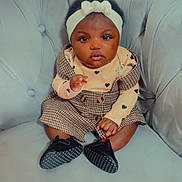 Marodette a rejoint le concours — aidez-le/la à gagner de superbes lots ! baby, child, infant, couch, headband, dress, heart_pattern, shoes, black_hair, cute, indoor, sitting, plush_furniture, portrait, looking_at_camera, young_child, fashion, adorable, soft_lighting, home