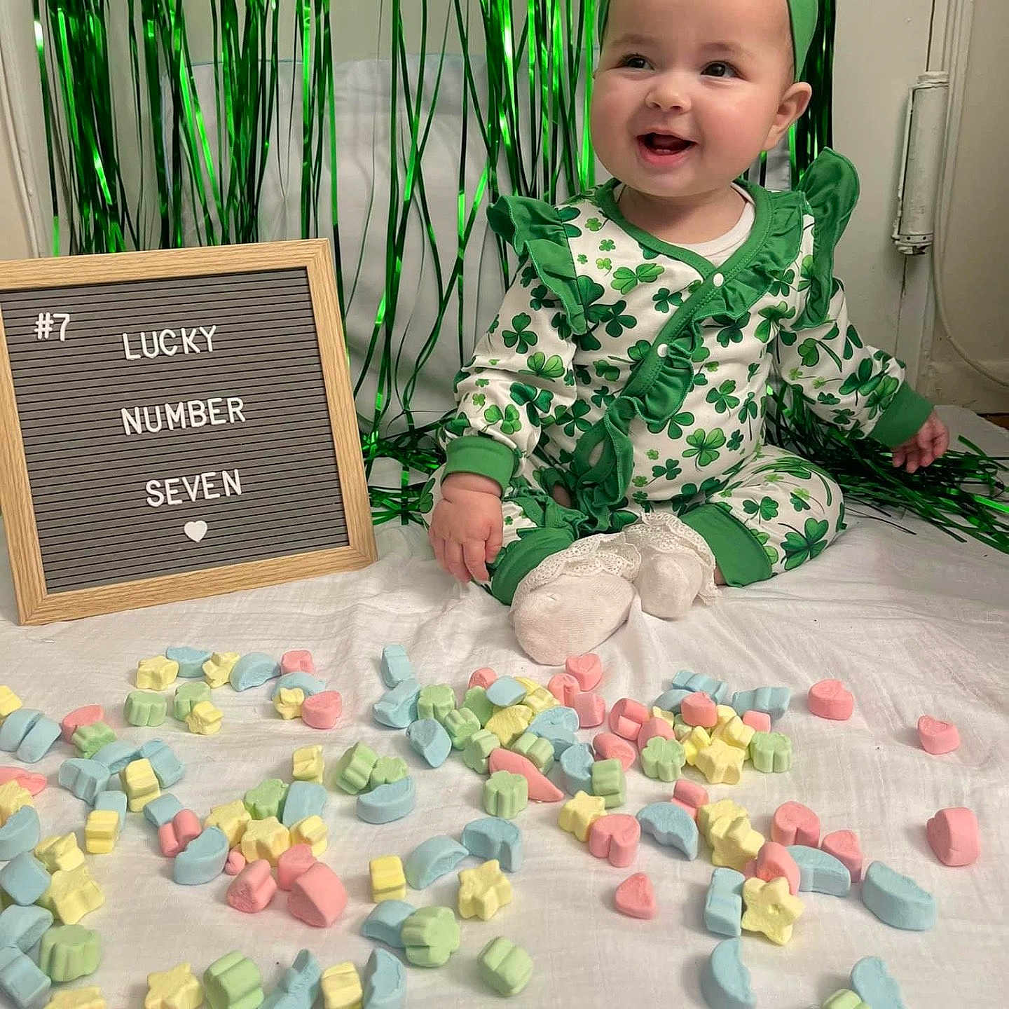 Elizabeth is registered to the contest to win money with this photo: accessories, baby, face, flower, green, happy, head, herbal, jewelry, necklace, number, person, petal, photography, plant, portrait, quilt, sitting, symbol, text