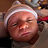 Lyra is registered to the contest to win money with this photo: baby, blanket, child, closeup, cozy, cute, expression, face, hat, headwear, hospital, indoors, infant, newborn, portrait, skin, sleepy, soft, warm_light, wrapped