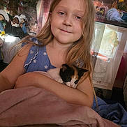 Cara is registered to the contest to win money with this photo: blanket, blue_dress, calico_cat, child, collection, cozy, cuddling, cute, dolls, girl, home, indoor, kitten, long_hair, pet, portrait, smiling, soft_light, toy, young