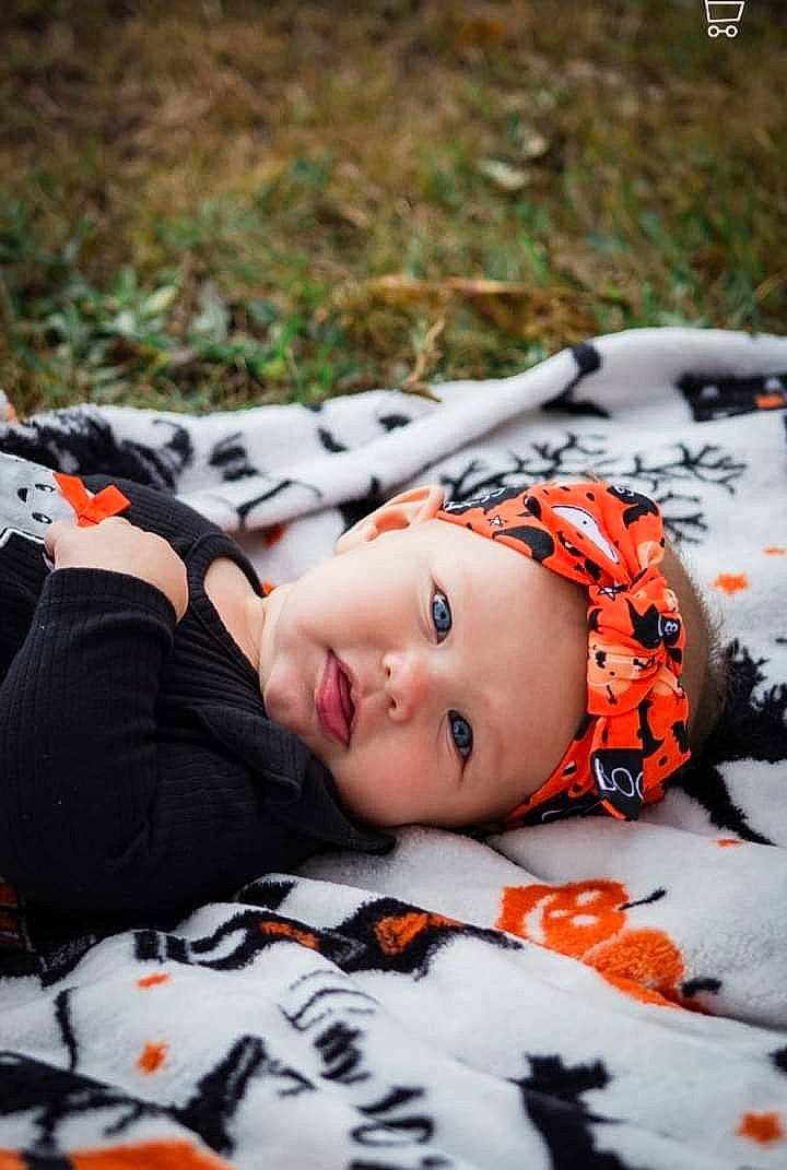 Avyanna joined the competition — help win amazing prizes! baby, baby_toddler_clothing, black, carmine, child, fashion_accessory, freezing, fun, grass, headwear, linens, orange, pattern, person, plant, recreation, sitting, toddler, tree, white