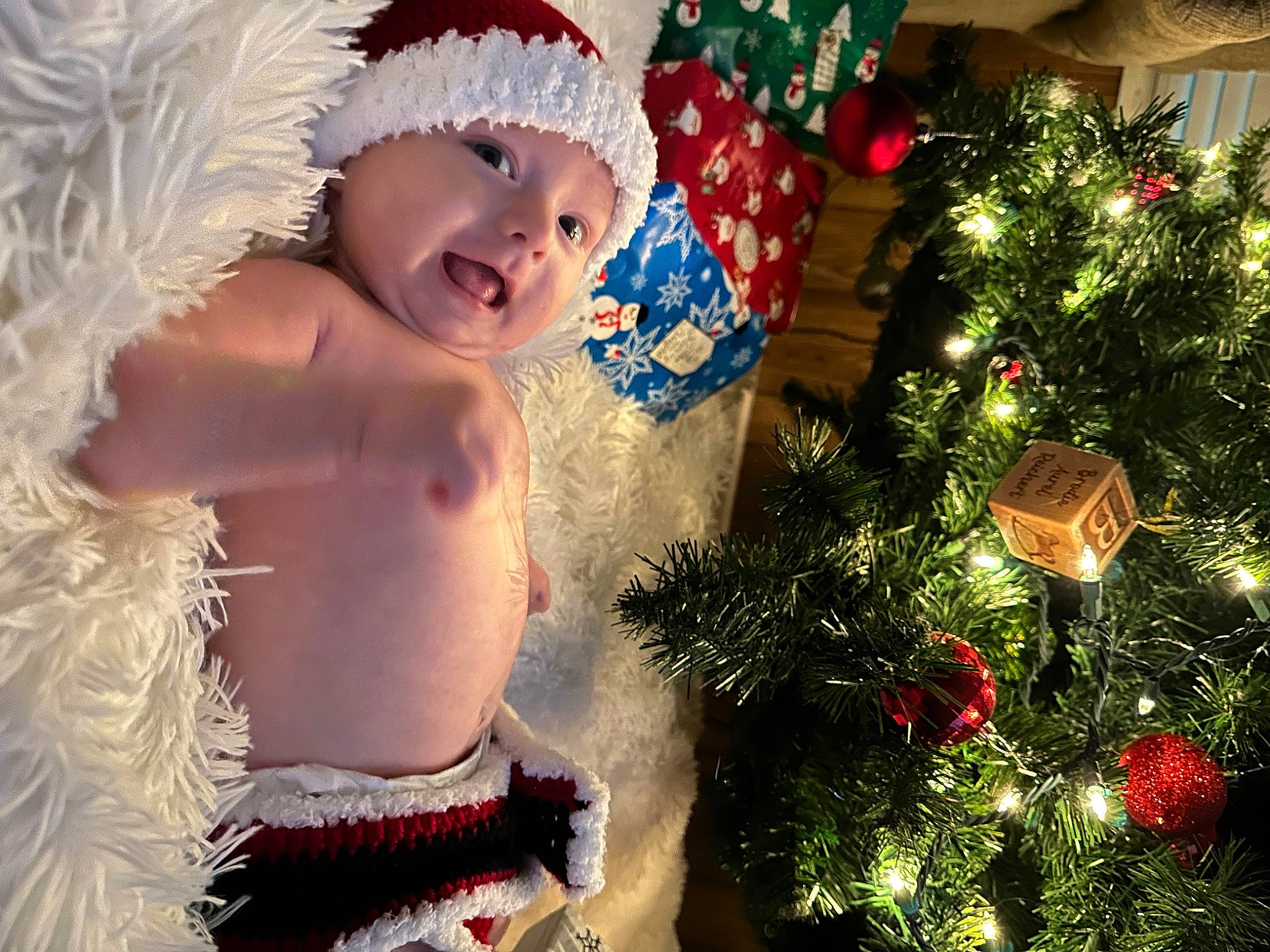 Brodie is registered to the contest to win money with this photo: baby, christmas, christmas_decoration, christmas_eve, christmas_ornament, christmas_tree, conifer, event, evergreen, happy, headwear, holiday, holiday_ornament, light, ornament, people_in_nature, person, santa_claus, smile, toddler